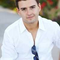Headshot of Daniel Pike, CEO Votre Allure. He is wearing a white button-up shirt with sunglasses dangling from the center.
